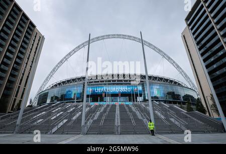 Londra, Regno Unito. 28 Giugno 2021. Calcio: Campionato europeo, nazionale, round di 16, prima della partita Inghilterra - Germania. Una guardia di sicurezza si trova di fronte alle scale per l'ingresso principale del Wembley Stadium. Credit: Christian Charisius/dpa - NOTA IMPORTANTE: In conformità con le norme del DFL Deutsche Fußball Liga e/o del DFB Deutscher Fußball-Bund, è vietato utilizzare o utilizzare fotografie scattate nello stadio e/o della partita sotto forma di sequenze fotografiche e/o serie fotografiche di tipo video./dpa/Alamy Live News Foto Stock