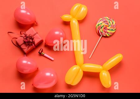 Composizione di compleanno con scatola regalo e palloncini su sfondo a colori Foto Stock