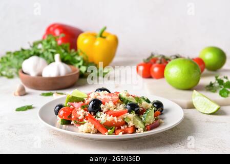 Piatto con couscous e verdure su sfondo chiaro Foto Stock