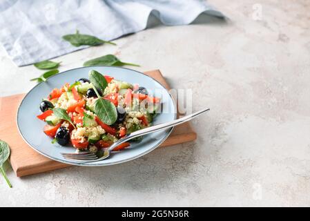 Piatto con couscous e verdure su sfondo chiaro Foto Stock
