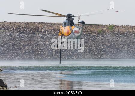 Un elicottero Sikorsky S-61 antincendio si riempie di acqua proveniente da un lago per la soppressione aerea degli incendi e la lotta antincendio nello Utah. Foto Stock