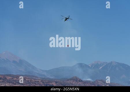 Un elicottero K-Max K-1200 Kaman che trasporta un elibucket per far cadere l'acqua su un fuoco selvatico nello Utah. Foto Stock