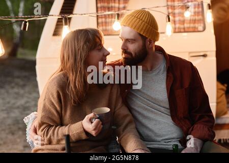 Giovane coppia godendosi l'un l'altro e bevendo il tè caldo all'aperto Foto Stock