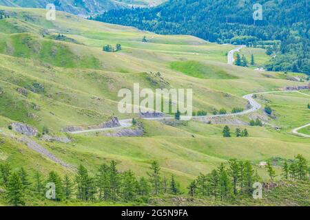 vista dalla cima della montagna, dal valico alla tortuosa e pericolosa strada di montagna sullo sfondo del paesaggio vallivo Foto Stock