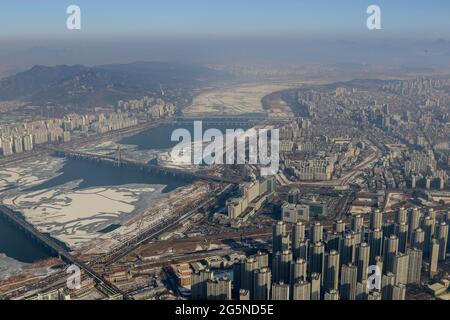 Scena diurna di Seoul, vista dalla cima della Lotte World Tower. La Lotte World Tower è un grattacielo alto 123 piani, 554.5 metri (1,819 piedi) che ha terminato la costruzione esterna il 17 marzo 2016. L'ultimo 123° piano dell'edificio è stato completato il 22 dicembre 2015. E' attualmente l'edificio piu' alto dell'OCSE ed e' il quinto edificio piu' alto del mondo. Foto Stock