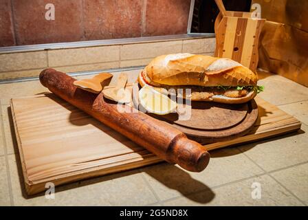 Sandwich di bistecca argentina Milanesa con insalata, pomodori, formaggio, uova, limone, salsicce, patatine. Alimenti per camion. Fast food. Messa a fuoco selettiva. Foto Stock