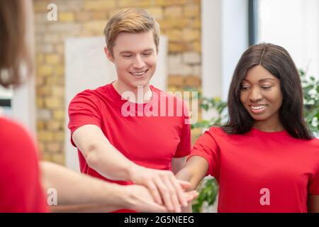 Ragazzo caucasico e ragazza dalla pelle scura che mostra il segno di togetherness Foto Stock