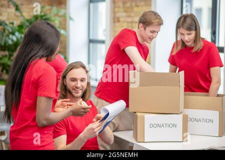 Gruppo di volontari studenti impegnati in un centro di beneficenza Foto Stock