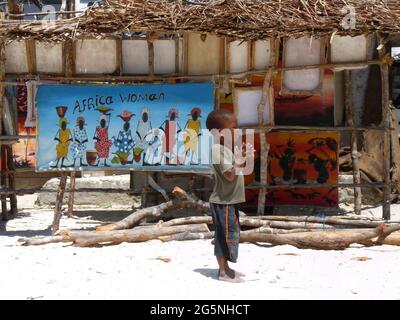 Giovane ragazzo africano in piedi da donne africane poster, Jambiani, Zanzibar Foto Stock