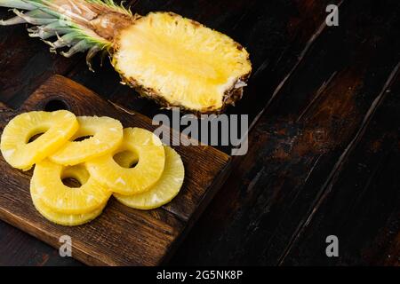 Tagli di fetta di ananas freschi impostati, su sfondo vecchio tavolo di legno scuro, con spazio di copia per il testo Foto Stock