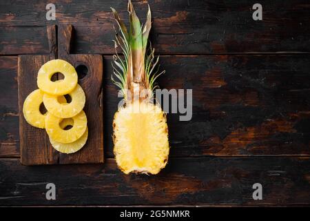 Set taglio ananas, su sfondo vecchio tavolo di legno scuro, vista dall'alto piatto, con spazio per la copia del testo Foto Stock