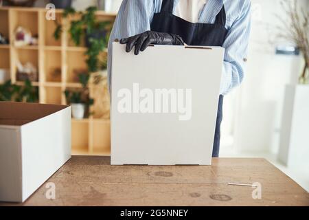 Arrangiatore floreale professionale che riunisce una scatola di cartone fiore Foto Stock