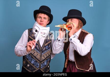 Artisti in maschere medico peste sui volti, sfondo blu Foto Stock