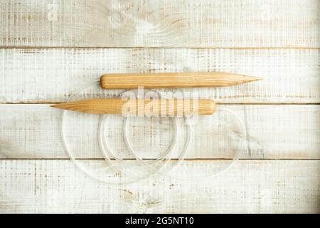 Spessi aghi in legno per maglieria di grandi dimensioni con merino lana su un pavimento di legno Foto Stock