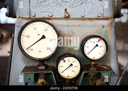 Apparecchiature di stile retrò di impianto chimico tre manometri o manometri mostrano zero closeup con fuori fuoco astratto background industriale con Foto Stock