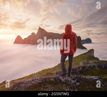 Un turista che gode di una vista sul monte Hesten, Senja, Norvegia. Trekking in Norvegia, concetto di vita attiva Foto Stock