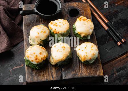 Panini giapponesi di sushi denominati EBI al forno con wasabi e pesce di salmone insieme, su sfondo vecchio tavolo di legno scuro Foto Stock