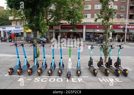 Panoramica generale degli e-Scooter gestiti da Dott, Lime e TIER presso un punto di noleggio e-Scooter a Kensington, West London Data immagine: Martedì 29 giugno 2021. Foto Stock