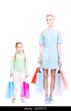 Studio ritratto scatto di giovane donna adulta passare il tempo con la sua figlia carina facendo shopping, sfondo bianco Foto Stock