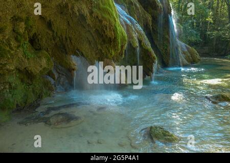 La cascata tuf vicino Arbois. Cascata cristallina, cascata potente. Foto Stock