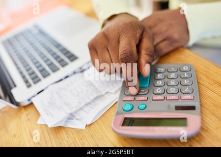 Digitazione a mano sulla tastiera del calcolatore per la contabilità e la dichiarazione dei redditi in ufficio Foto Stock