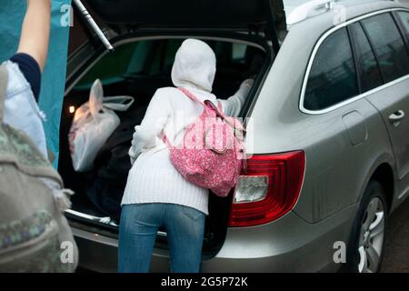 Hanno messo le cose nel tronco. Viaggio in famiglia in auto. Caricamento di oggetti in auto. La famiglia si sta muovendo. Foto Stock