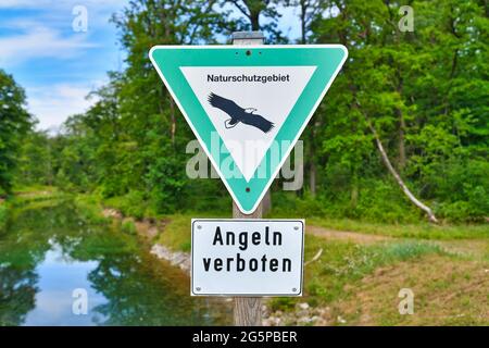 Cartello tedesco per la Riserva Naturale tedesca e cartello 'no fishing' di fronte al fiume Foto Stock