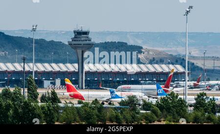 MADRID, SPAGNA - 26 giu 2021: Madrid Bajaras, 26 giugno 2021: Vista ingrandita degli aeroplani su asfalto e il tetto iconico dell'aeroporto di Bajaras a Madrid, Spagna Foto Stock