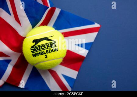 LONDRA, UK - Giugno 2021: Palla ufficiale di tennis di wimbledon Slazenger sulla bandiera del regno unito Foto Stock