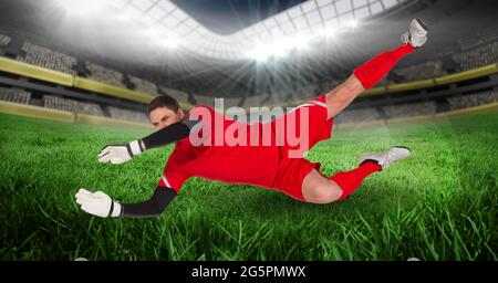 Composizione del portiere maschile che cattura la palla allo stadio Foto Stock