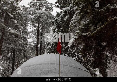 Uno scatto da vicino di uno scenario che cattura una bandiera turca su un tetto durante la stagione invernale. Foto Stock