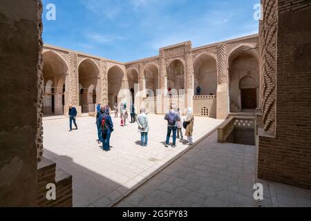 Yazd, Iran - 13.04.2019: Persone che camminano nel cortile della storica Moschea Jameh di Naein, provincia di Yazd, Iran, architettura islamica molto antica i Foto Stock