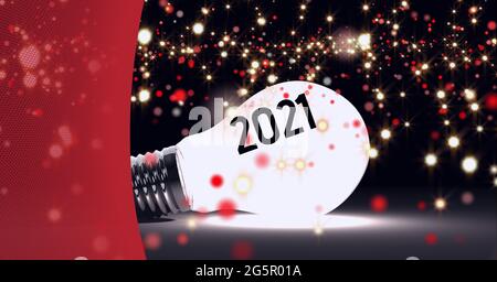 2021 testo e punti di luce dorati su una lampadina incandescente su sfondo rosso Foto Stock