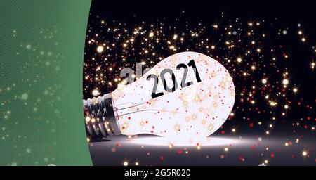 2021 testo e punti di luce dorati su una lampadina luminosa con sfondo verde Foto Stock