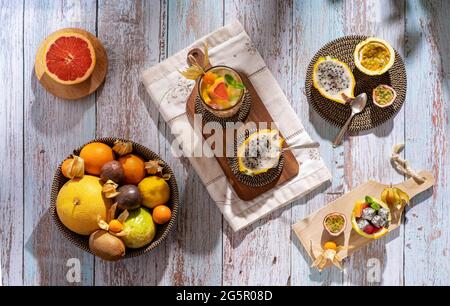 Piatto Lay brillante fotografia alimentare di mix di frutta tropicale a fette. Vista dall'alto di un vassoio con frutto della passione, maracuya, physalis, arancio, frutta drago e. Foto Stock