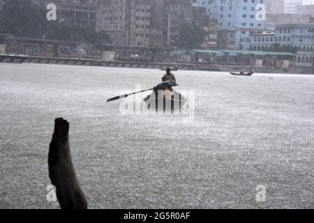 I pendolari del Bangladesh utilizzano le barche per attraversare il fiume Buriganga durante la pioggia a Dhaka, Bangladesh, il 29 giugno 2021. Foto Stock