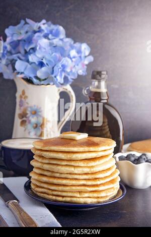 Pila di frittelle americane appena fatte con burro metallante Foto Stock