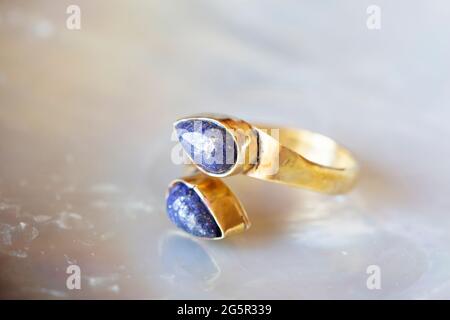 anello in ottone con pietra minerale su sfondo naturale Foto Stock