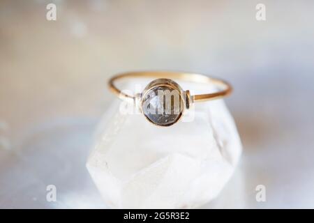 anello in ottone con pietra minerale su sfondo naturale Foto Stock
