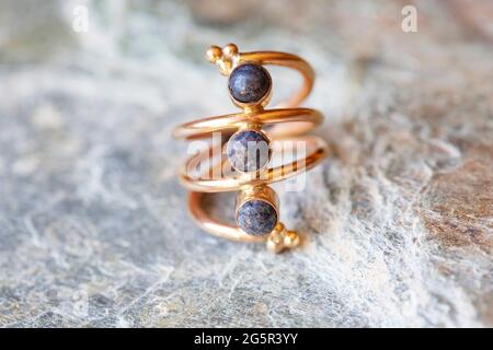 anello in ottone con pietra minerale su sfondo naturale Foto Stock