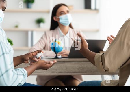 Agenzia di viaggi per famiglie africane, che parla con l'Agente in ufficio Foto Stock