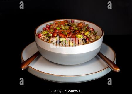 Insalata di noce di legno integrale guarnita con melograno, un gustoso pranzo vegano Foto Stock