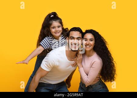 Tempo di famiglia. Ritratto di felici genitori arabi e figlia che si divertono insieme Foto Stock
