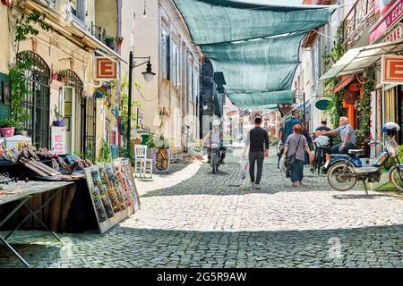 Urla, İzmir, Turchia - Giugno, 2021: Negozi di souvenir, caffè e persone in via d'arte Urla a İzmir, Turchia. Foto Stock