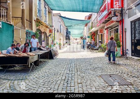 Urla, İzmir, Turchia - Giugno, 2021: Negozi di souvenir, caffè e persone in via d'arte Urla a İzmir, Turchia. Foto Stock