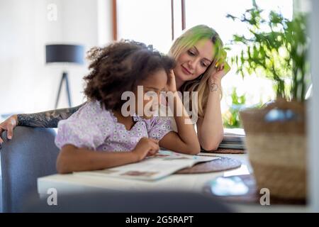 Madre aiutare mia figlia con i compiti Foto Stock