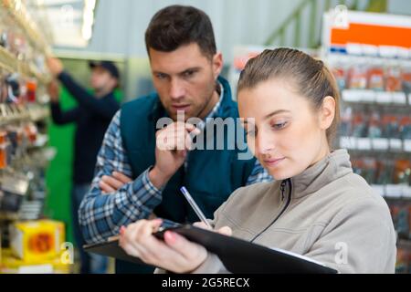 addetto all'inventario degli scaffali dei negozi hardware Foto Stock