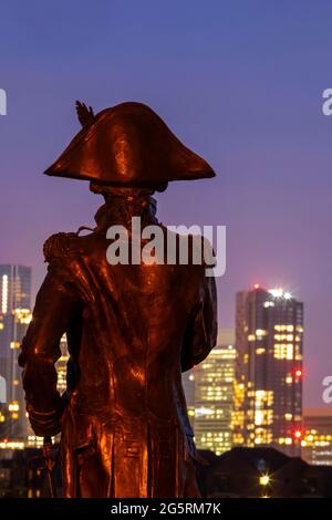 Inghilterra, Londra, Greenwich, la statua di Silouette of Lord Nelson e lo skyline di notte di Canary Wharf Foto Stock