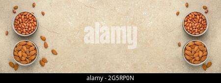 Fondo del dado. Banner per la stampa di grande formato, la pubblicità e il design del sito web. Noci di diverse varietà si trovano in ciotole su un piano di pietra, top Foto Stock