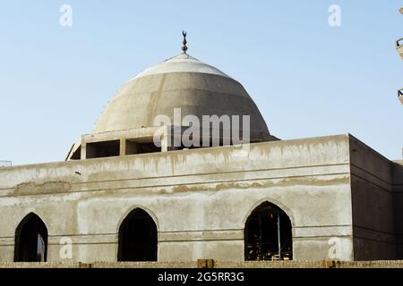 Una nuova moschea in costruzione contro il cielo azzurro soleggiato con il minareto moschea circondato da impalcature di legno e la cupola Foto Stock